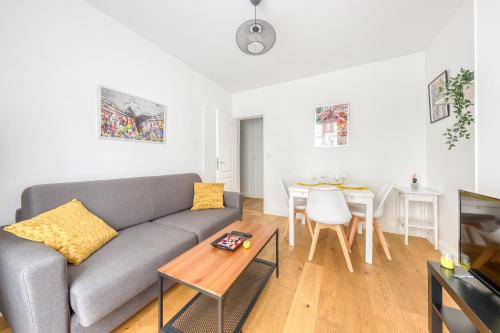 un salon avec un canapé et une table dans l'établissement Parking gratuit - Central et cosy - 2 min Paris, à Clichy