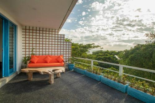a bench on the balcony of a house with a view at Hossegor - Tropical 1 Bedroom Ocean View Apartment by Triang Villas in Tanah Lot