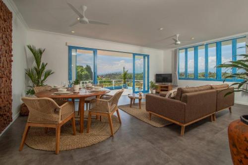 a living room with a table and chairs and a couch at Hossegor - Tropical 1 Bedroom Ocean View Apartment by Triang Villas in Tanah Lot