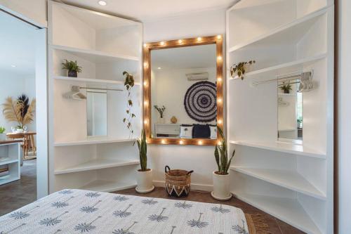 a bedroom with white shelves and a mirror at Pavones - Tropical Oceanfront 1 Bedroom Apartment by Triang Villas in Tanah Lot