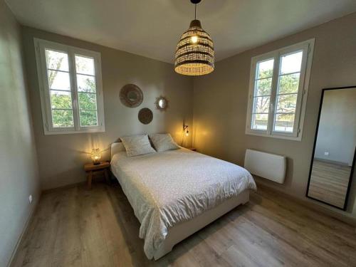 a bedroom with a bed and a pendant light at Cante alaoude in Linxe