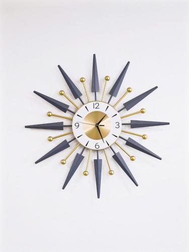 a clock with black and gold hands on a white background at Seafront Apartment TMS Quy Nhơn in Quy Nhon