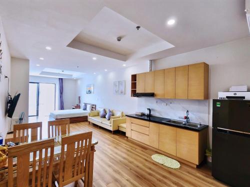 a kitchen and living room with a couch and a table at Seafront Apartment TMS Quy Nhơn in Quy Nhon