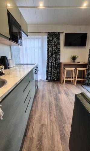 an office with a kitchen with a desk and a table at Loch Lomond Waterfront Luxury Lodges in Balmaha