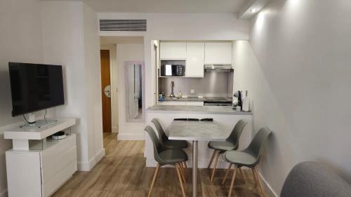 a kitchen with a table and chairs and a television at Suite Prestige Paris-La Défense Balcon-Terrasse in Courbevoie