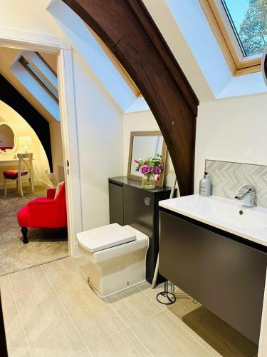 a bathroom with a sink and a red chair at The Bell Tower in Bonnybridge