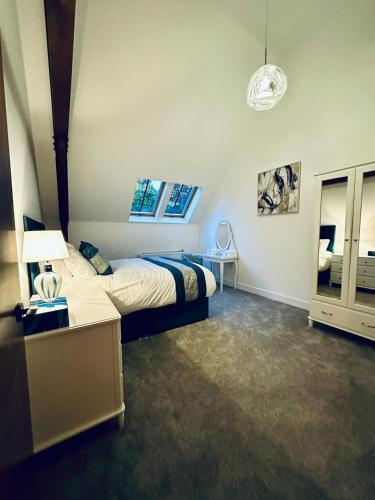 a bedroom with a bed and a desk and a lamp at The Bell Tower in Bonnybridge