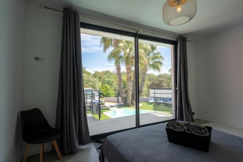 - une chambre dotée d'une grande fenêtre offrant une vue sur la piscine dans l'établissement Villa Luxe & Éco -Rêve et Nature Pool et Spa, à Roquebrune-sur Argens