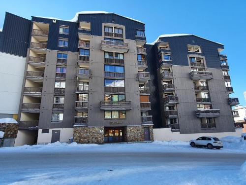 a large building with a car parked in front of it at Cime de Caron - Appartement cosy refait à neuf 4 personnes - Valthosun - Val Thorens in Val Thorens