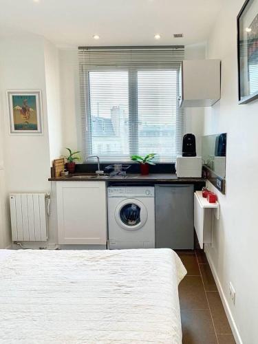 une cuisine avec une machine à laver dans une pièce dans l'établissement Private Studio 15m2 a Porte Maillot, à Paris