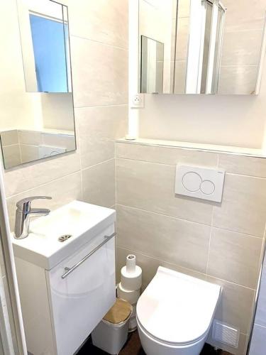 une salle de bain avec toilettes, lavabo et miroir dans l'établissement Private Studio 15m2 a Porte Maillot, à Paris