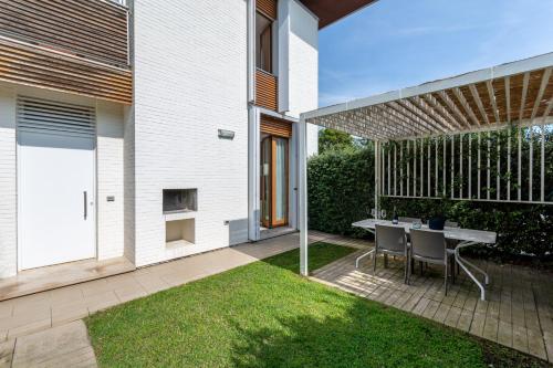 a patio with a table and chairs in a yard at Isola di Albarella in Isola Albarella