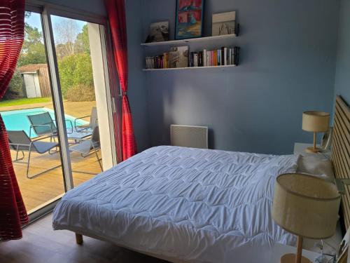 - une chambre avec un lit et une vue sur une terrasse dans l'établissement Villa Pyla sur mer 10 couchages, à La Teste-de-Buch