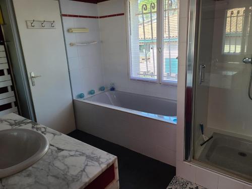une salle de bain avec une baignoire, un lavabo et une douche dans l'établissement Villa Pyla sur mer 10 couchages, à La Teste-de-Buch