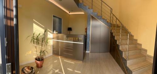 a hallway with a staircase and a potted plant at Pensiune cu restaurant Bigfast in Luduş