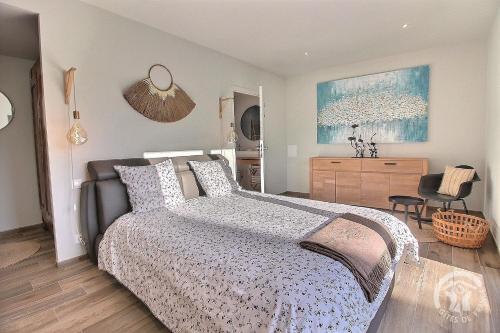 a bedroom with a bed and a dresser and a chair at Cocon maritime in Gicquel