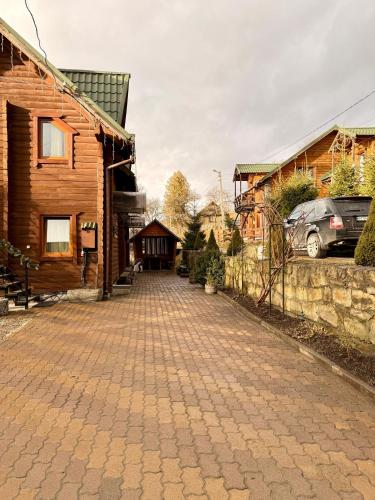 a cobblestone street in front of a wooden house at Водограй in Vorokhta
