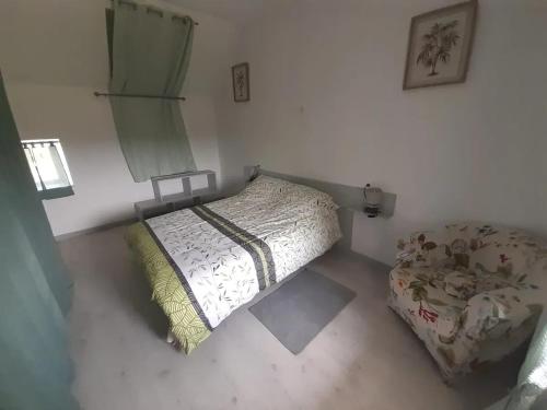 a bedroom with a bed and a chair in it at Maison conviviale près de Charron avec jardin, 100 m² in Charron