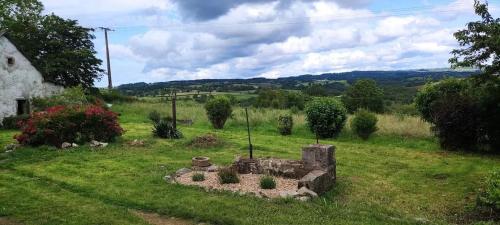 a garden with a stone structure in the grass at Maison conviviale près de Charron avec jardin, 100 m² in Charron