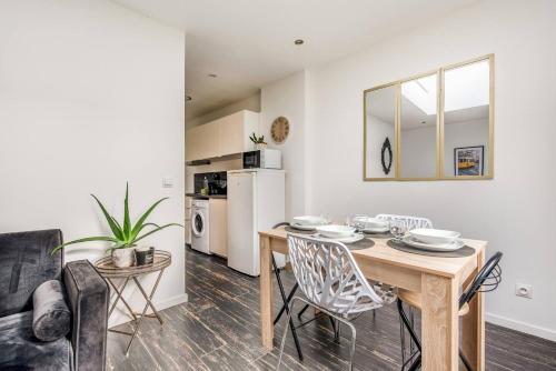 une cuisine et une salle à manger avec une table et des chaises dans l'établissement Magnifique Cocon à Lille Lomme, à Lille