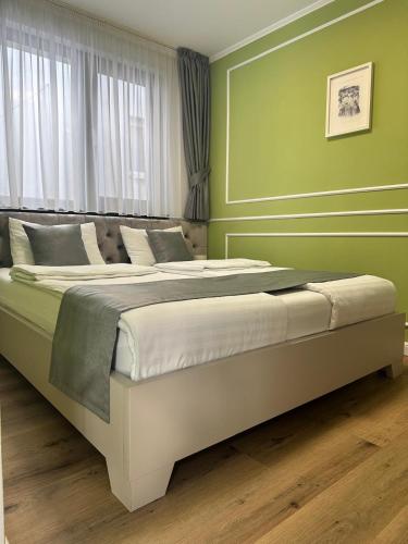 a bedroom with two beds with green walls at Pensiune cu restaurant Bigfast in Luduş