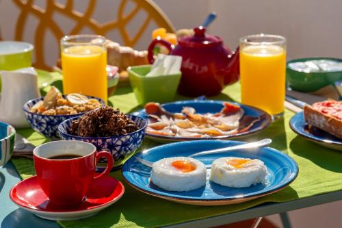 a table with plates of breakfast food and cups of coffee at Boutique Hotel El Olivar in Mojácar