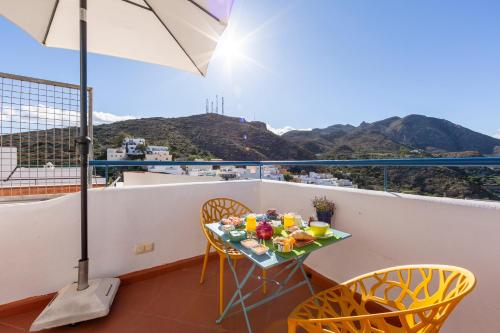 a balcony with a table and chairs and an umbrella at Boutique Hotel El Olivar in Mojácar