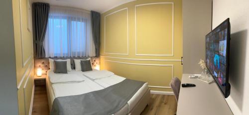 a hotel room with a bed and a flat screen tv at Pensiune cu restaurant Bigfast in Luduş