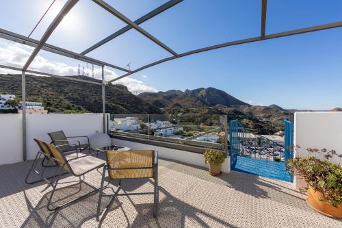 a balcony with chairs and a view of the mountains at Boutique Hotel El Olivar in Mojácar