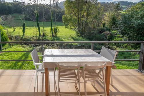 a table and chairs on a deck with a view at Laga Blue Surf in Ibarrangelu