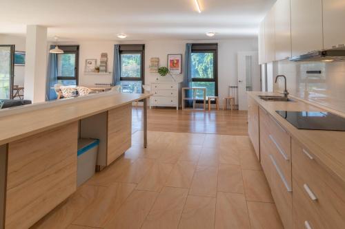 a large kitchen with wooden counter tops and a living room at Laga Blue Surf in Ibarrangelu