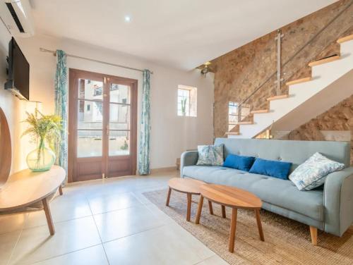 a living room with a blue couch and stairs at Cas Mercader in Algaida