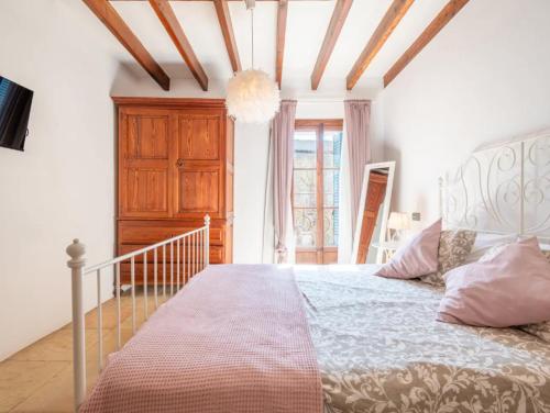 a bedroom with a large bed with a wooden ceiling at Cas Mercader in Algaida
