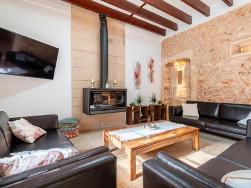 a living room with leather furniture and a fireplace at Cas Mercader in Algaida