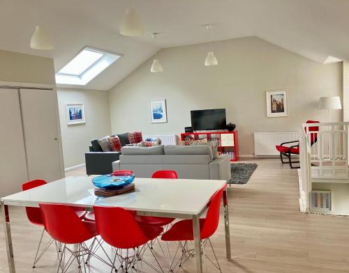 a living room with a white table and red chairs at Park Mews Glasgow in Glasgow