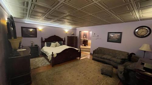 a bedroom with a bed and a couch and a clock at The Yorkshire Inn in Phelps
