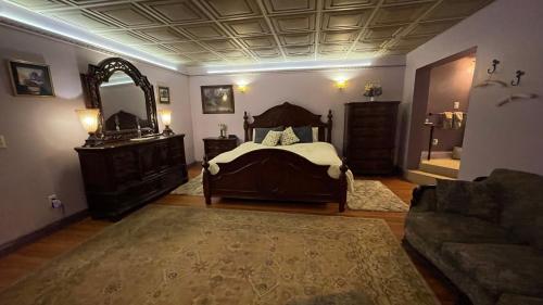 a bedroom with a bed and a mirror and a couch at The Yorkshire Inn in Phelps