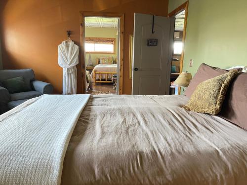a bedroom with a large white bed with a dress hanging on the wall at The Yorkshire Inn in Phelps