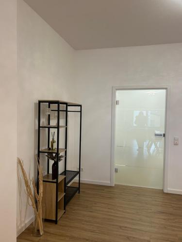 a white room with a shelf and a table at Schöne Ferienwohnung im Zentrum in Schwandorf in Bayern
