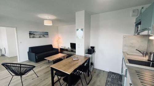 un salon avec une table et un canapé dans l'établissement Le Lumina du centre bourg, à Saint-Jean-de-Monts