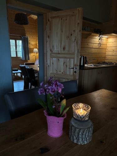 a vase of purple flowers on a wooden table at Het Hilkensberg Park in Broekhuizen