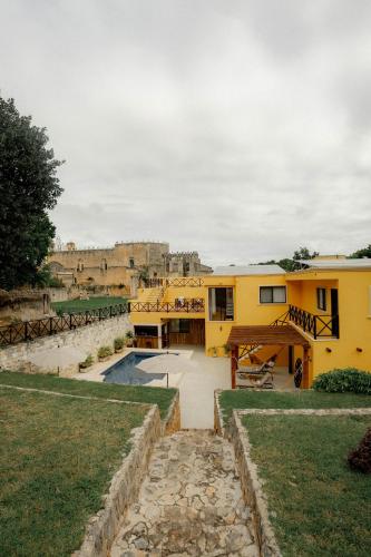 a view of a yellow building with a pool at Hotel Rinconada del Convento in Izamal