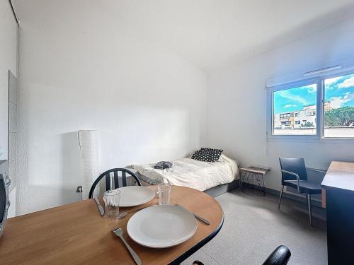 Cette petite chambre comprend une table et un lit. dans l'établissement Le Central FAC, Charmant studio à Montpellier, à Montpellier