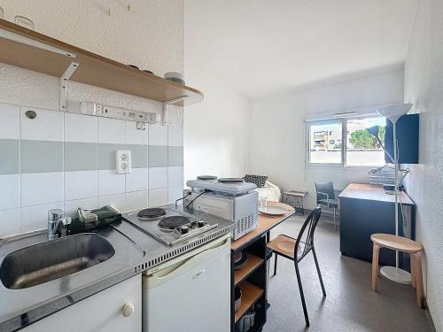 une cuisine avec un évier et une cuisinière four supérieur dans l'établissement Le Central FAC, Charmant studio à Montpellier, à Montpellier