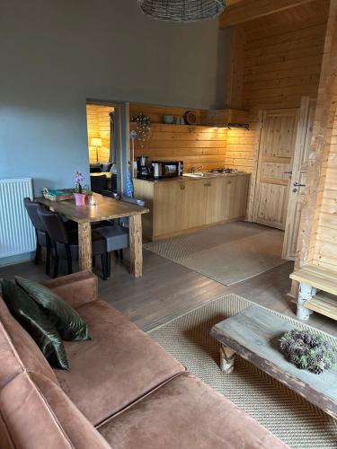 a living room with a couch and a table at Het Hilkensberg Park in Broekhuizen