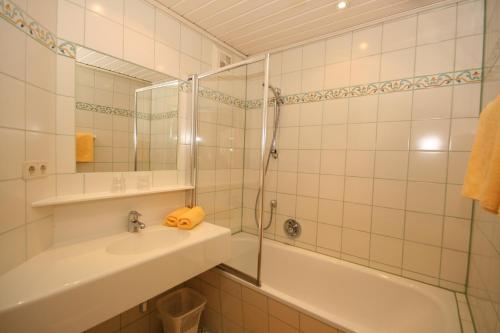 a bathroom with a sink and a shower and a tub at Gästehaus Katharina in Schladming