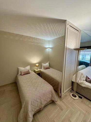une petite chambre avec deux lits et un miroir dans l'établissement Résidence Gray d'Albion Studio LEF516, à Cannes