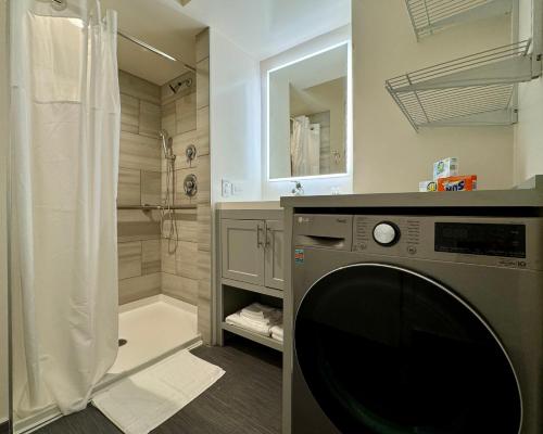 a washing machine in a bathroom with a shower at The GEM Museum Suites in Evanston