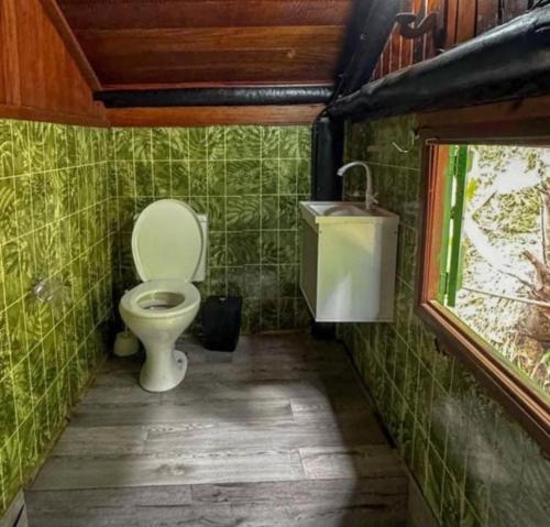 Un baño pequeño con inodoro y lavabo. en Encontro dos Mares Chalés Lázaro, en Ubatuba