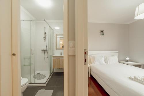 a bedroom with a bed and a shower and a bathroom at Espinho Seawalk and Seaview by Vacationy in Porto